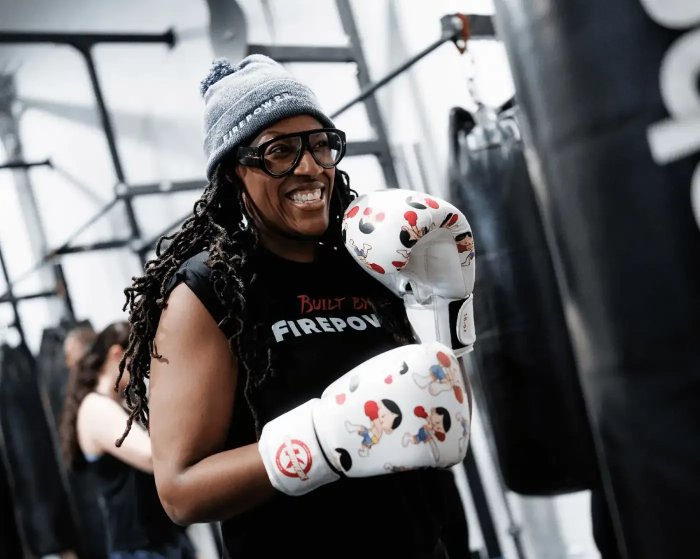A smiling FirePower boxing coach wrapped and gloved up